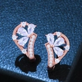 Orecchini a fiore in oro rosa con zirconi su uno sfondo di pelle blu scuro - Bianco