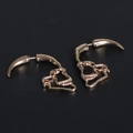 Macro view of gold skull horn earrings with gothic punk style and metallic finish - Gold