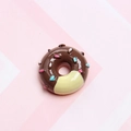 Close-up of a brown resin donut charm with colorful sprinkles on a striped background - Light Coffee
