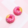 Macro shot of realistic pink resin donut charms with colorful sprinkles and stripe pattern - Rose Red