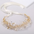 Elegante diadema de novia dorada con perlas y cristales sobre un fondo minimalista - Dorado