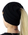 Close-up of black cable knit ponytail beanie showing the elastic top opening on a model - Black