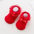 Detailed close-up of red infant socks with lace frills and white polka dot bow accents - 0-6 Months / Red