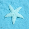 Dettaglio di una stella marina in resina blu chiaro su sabbia blu per progetti fai-da-te - Azzurro