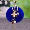 Deep blue faux fur pompom keychain with gold key and heart pendants on a lobster clasp - Clover Key + Royal Blue Pom Pom