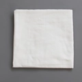 Lange en mousseline de coton blanc plié pour bébé sur un fond gris doux et épuré - Blanc uni
