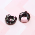 Detailed close-up of resin chocolate doughnuts with pink frosting and colorful sprinkles - Dark Coffee