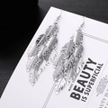 Bohemian silver feather layered tassel earrings on white card with metallic texture - H4680 Feather Multi-layer