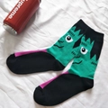 Detail von Socken mit grünem Monstermuster und lila Spitze auf weißem Stoffhintergrund - 36-44 / Grüner Frankenstein