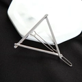 Macro shot of minimalist silver metal triangle hair clip on white ceramic plate - Triangle Silver
