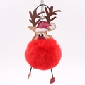 Close-up of a festive Christmas reindeer keychain with a soft red faux fur pompom ball - Red
