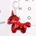 Detail of red sequin horse keychain with metallic ring on a white decorative card - Red