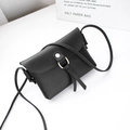 Mini black crossbody bag featuring a golden ring, tassels, and premium faux leather finish - Black