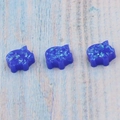 Dettaglio di tre ciondoli a forma di maiale in opale blu scintillante per gioielli fai-da-te - Maialino Senza Foro / Blu
