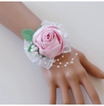 Detail der Handgelenk-Korsage aus rosa Satinrose mit Spitze und weißen Perlen für Braut - Hellrosa