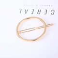 Detail of minimalist golden circular metal hair clip with polished finish on white background - Circle Gold