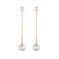 Detail shot of long drop earrings with gold bead chains and two sized faux pearls - Gold