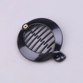 Close-up of black plastic banana clip showing internal comb teeth and metal hinge - Black