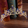 Detailaufnahme einer goldenen Brautkrone mit königsblauen Saphiren auf antiken Büchern - Gold Königsblau
