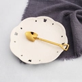 Cuillère pelle en acier inoxydable doré avec poli miroir sur une soucoupe en céramique - Cuillère Pelle en Or Titane