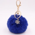 Detail van blauwe pluche pompon sleutelhanger met gouden sneeuwvlok en karabijnsluiting - Koningsblauw