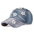 Detailed macro view of denim baseball cap with white floral appliqués and silver rhinestones - Adjustable / Light Denim Blue