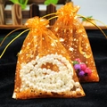 Two orange star and moon organza gift bags filled with pearls and colorful beads - Orange