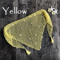Detalle de chal playero de ganchillo amarillo con borlas de conchas sobre fondo de madera - Talla única / Amarillo