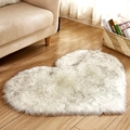 Plush heart-shaped rug in white with grey tips on wooden floor near sofa - White Black Tips