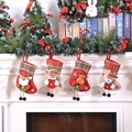 Lot de 4 chaussettes de Noël avec Père Noël et bonhomme de neige sur une cheminée - Lot de 4 petites chaussettes avec figurines à carreaux