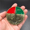 Macro shot of 3D bronze Dubai Burj Khalifa souvenir magnet with red and green enamel detailing - Burj Khalifa Dubai