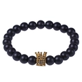 Bracciale in pietra lavica naturale con ciondolo a corona dorata su sfondo bianco - Stile Pietra Opaca