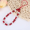 Close-up of red beaded phone charm with crystal-studded silver beads and floral pendant - A143 Red Beaded Bracelet