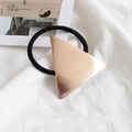 Geometrischer roségoldener Dreieck-Haargummi mit schwarzem Gummiband auf Leinen - Metall / Dreieck Roségold