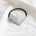 Chic silver V-shaped metal geometric hair tie with black elastic band on white linen - Metal / Geometric Silver