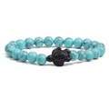 Detail of beaded turquoise bracelet featuring a black carved sea turtle charm centerpiece - Light Turquoise