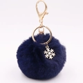 Detail van donkerblauwe nepbont pompon met gouden sneeuwvlok hanger en sleutelhanger - Marineblauw