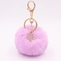 Close-up of pink fluffy faux fur pompom keychain with golden snowflake charm and clasp - Light Purple
