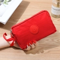 Pochette in tessuto rosso con tre cerniere e logo sportivo su legno chiaro - Rosso