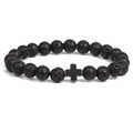 Detailed view of black volcanic stone beads and metallic cross charm on a stretch bracelet - Black