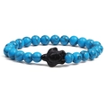 Close-up of sky blue marbled beads with a black sea turtle charm on the bracelet - Blue Turquoise