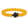 Detail of yellow round beaded elastic bracelet featuring a black carved turtle center bead - Agate