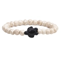 Macro detail of white marble stone beads and a black turtle charm on a stretch bracelet - Howlite