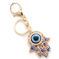 Makroaufnahme von Hamsa-Hand Schlüsselanhänger mit blauem Auge und Kristallen - Gold