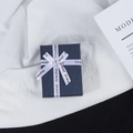 Dettaglio di una scatola regalo blu scuro con nastro di seta bianco su tessuto bianco - Scatola con Fiocco Blu Inchiostro (7*9CM)