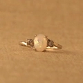 Eleganter versilberter Opalring mit ovalem weißem Stein und Diamantakzenten auf gelbem Grund - US 5 / Weiß