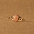Eleganter vergoldeter Ring mit ovalem rosa Opal und funkelnden Diamantakzenten an den Seiten - Rosa