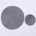 Close-up of grey woven round placemats showing durable texture and heat resistance - Dark Gray