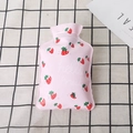 Detail of pink PVC hot water bottle with strawberry print on checkered background - Strawberry