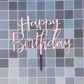 Pink Happy Birthday cake topper made of acrylic on a blue mosaic tile background - Rose Gold